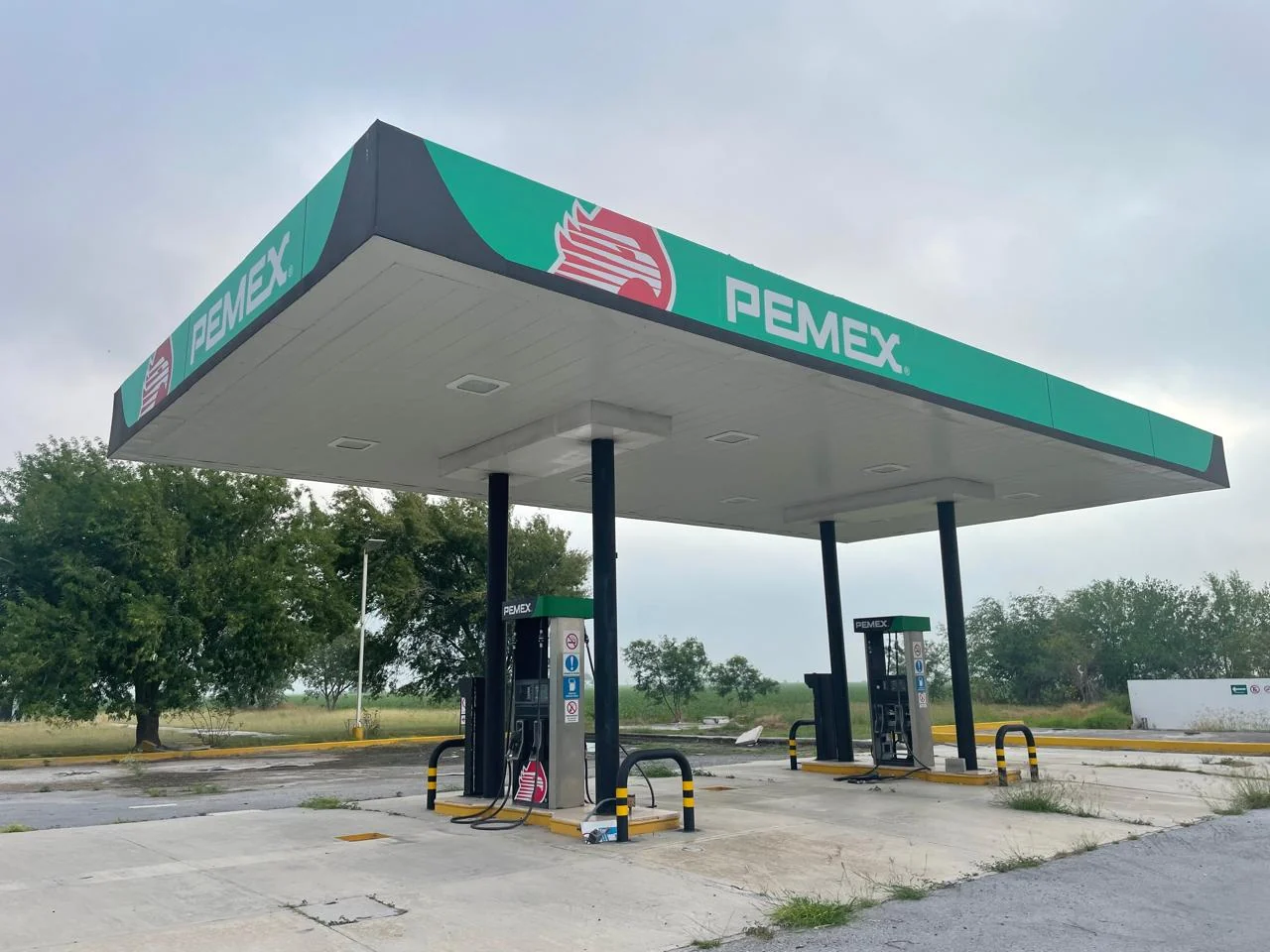 Estación PEMEX con canopy y área de servicio en vista diurna