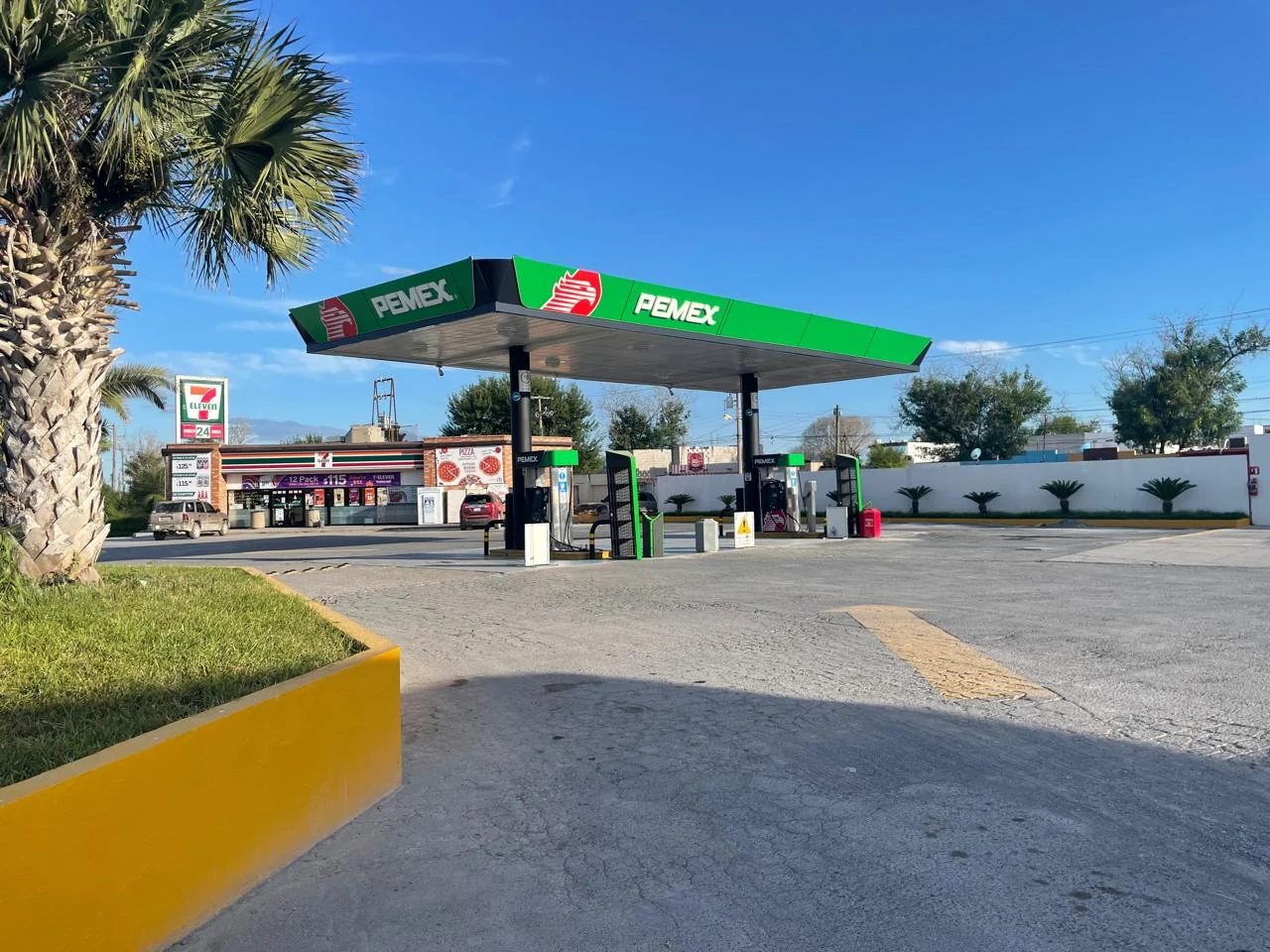 Estación PEMEX con canopy verde y acceso ajardinado